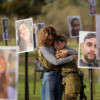 Israeli soldiers hugging surrounded by hostage posters.